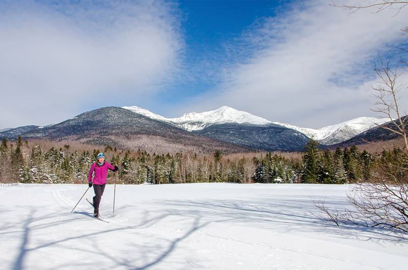 Female Cross Country Skiing at Great Glen Trails with Mount Washington in Background