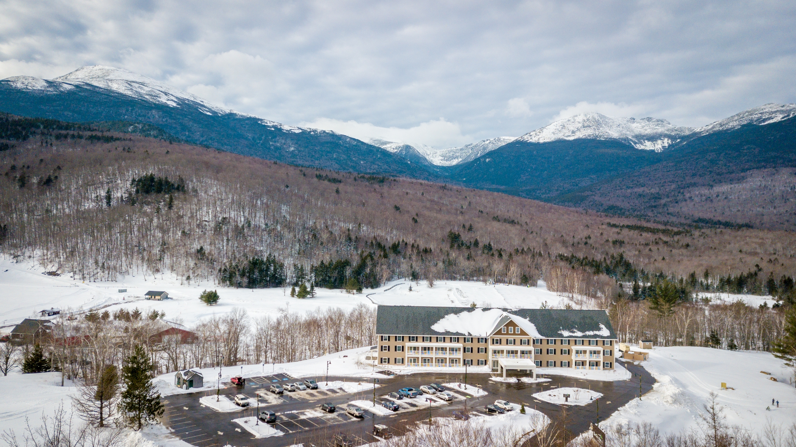 Aerial shot of The Glen House during the winter with mountains in the background